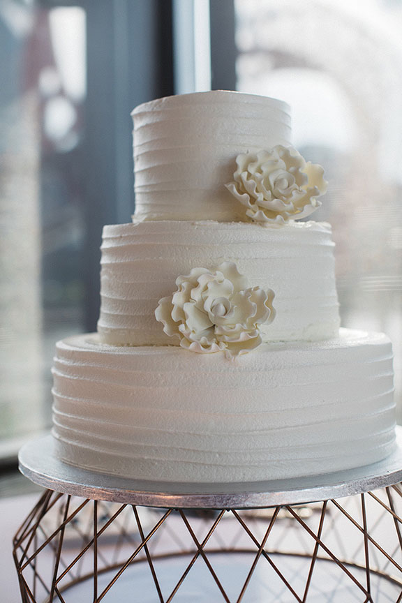 White Textured Three-Tiered Wedding Cake With White Florals