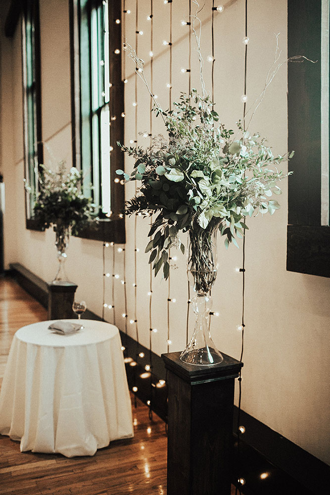 Wedding Ceremony Greenery Arrangements with String Light Backdrop