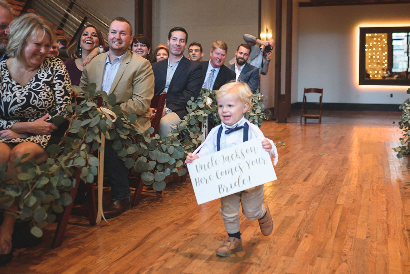 Ring Bearer Running Down Aisle With Sign