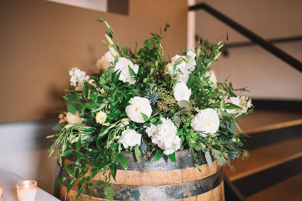 White & Green Floral Arrangement on Whiskey Barrel