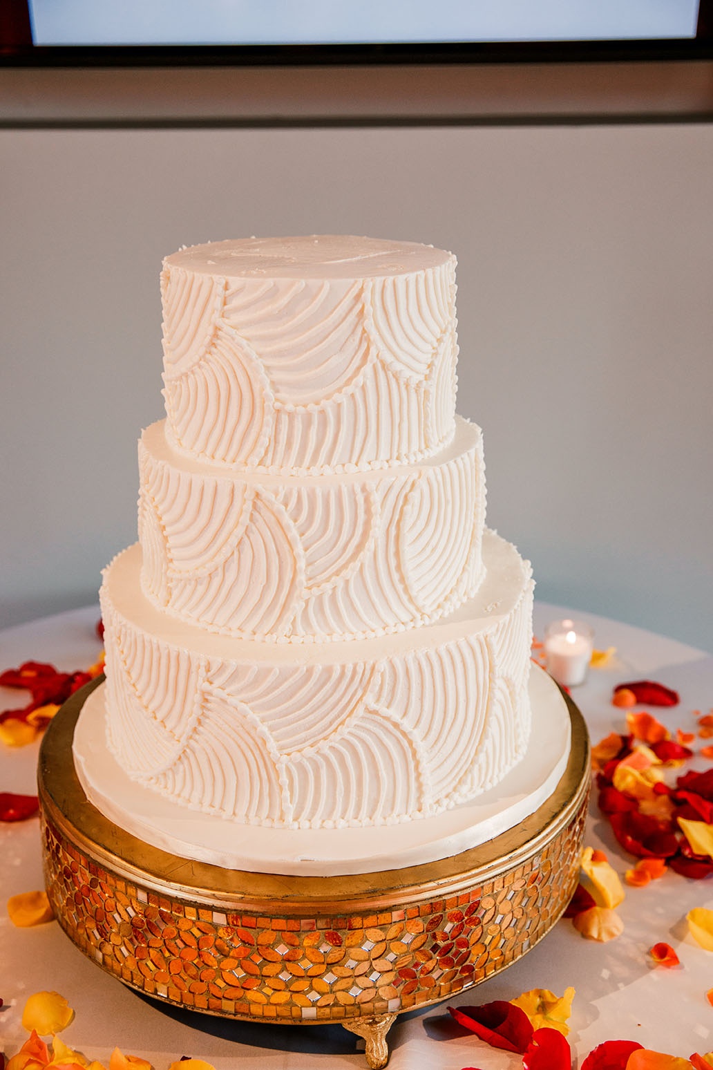 Three-Tiered White Wedding Cake on Gold Stand