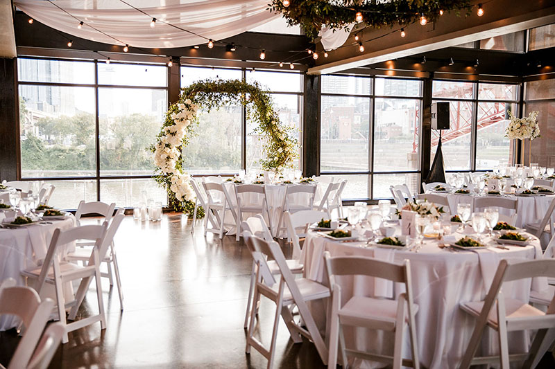 Cumberland Space with White Reception Seating and Greenery Arch