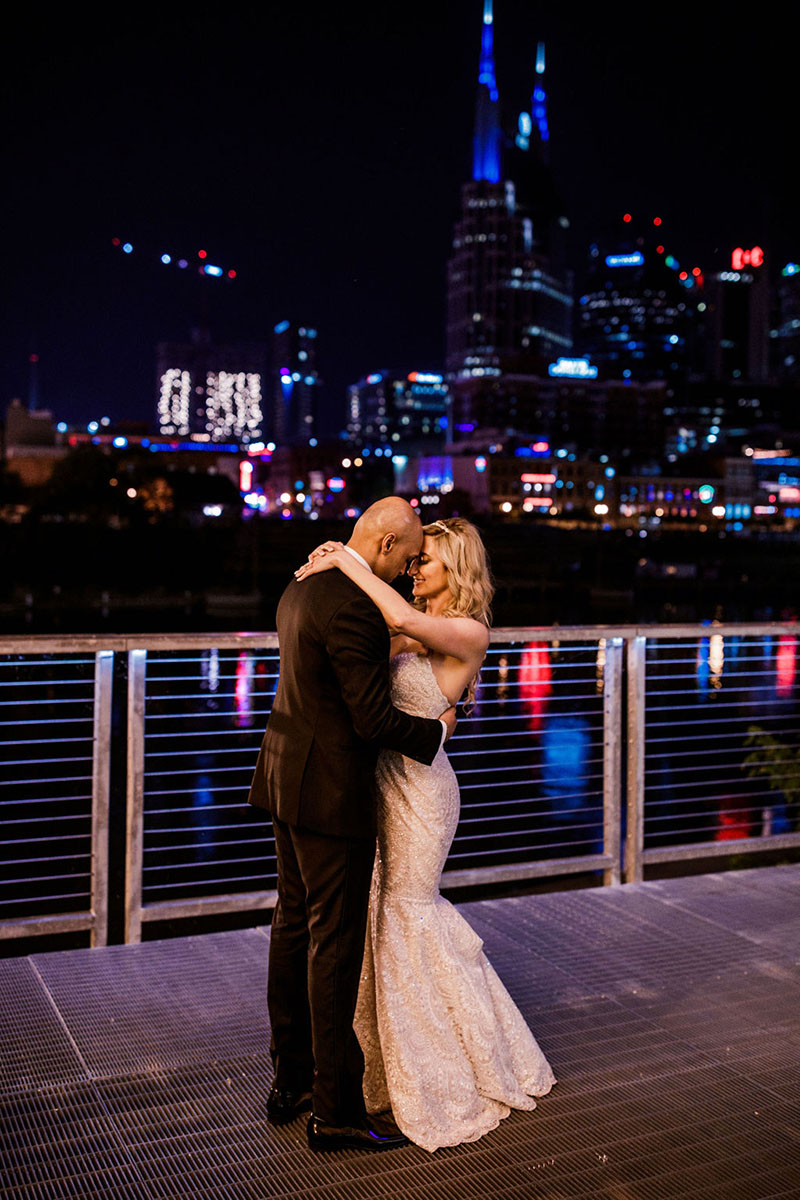 Megan and Bravein Embracing on Riverfront at Night