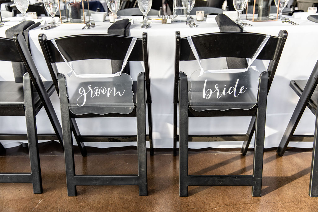 Lucite Bride and Groom Seat Signs on Black Chairs