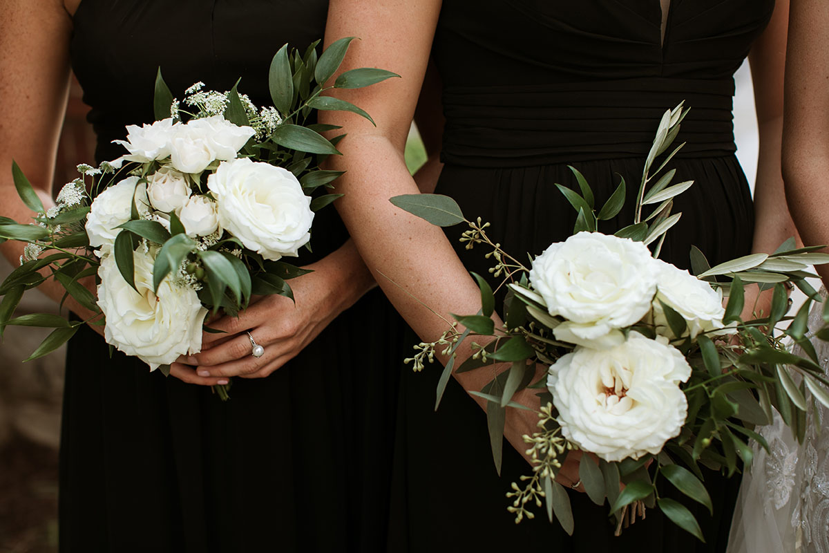 Bridesmaids Holding White Rose Bouquets with Greenery