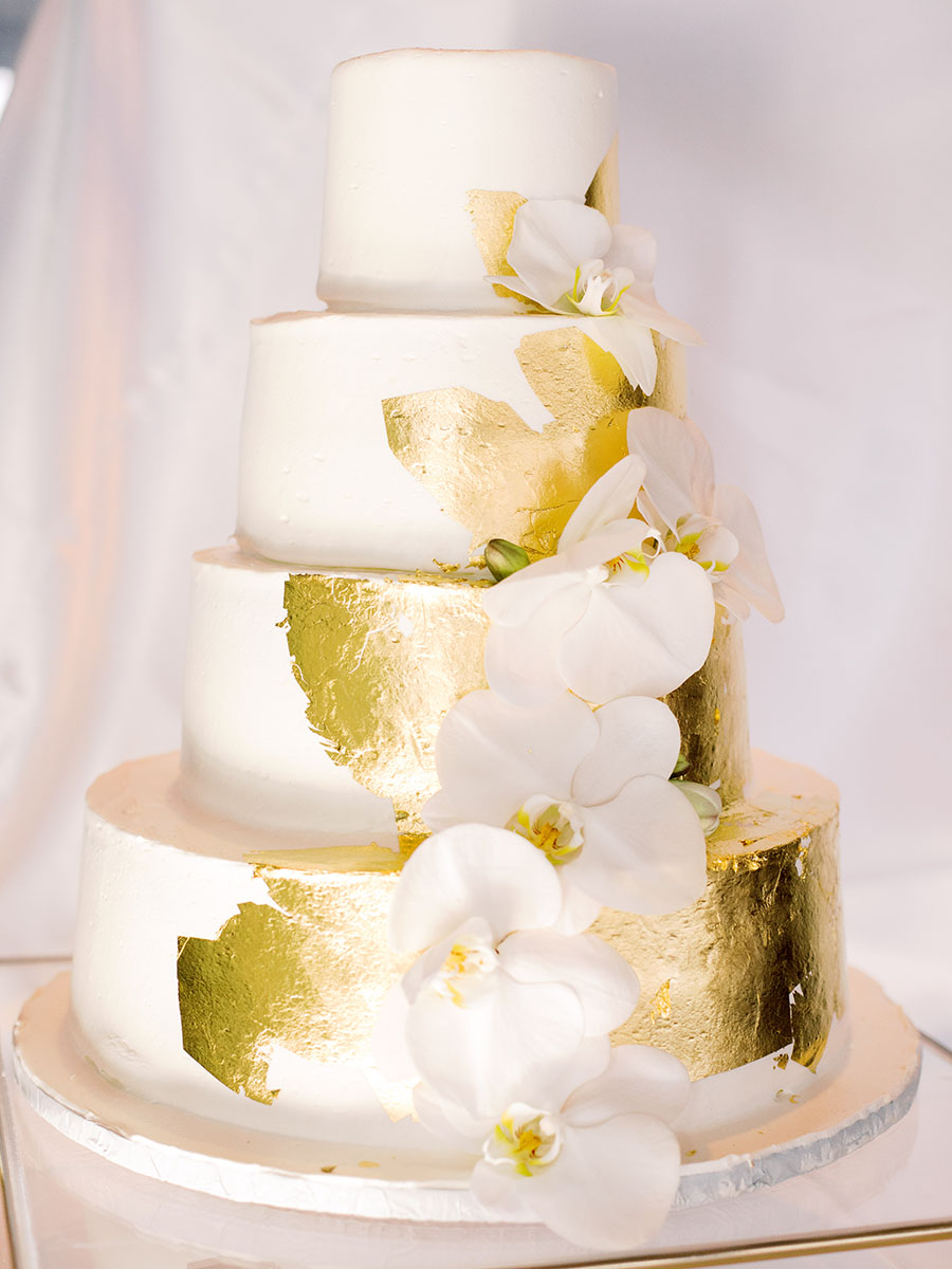 Tiered gold foiled wedding cake with orchids