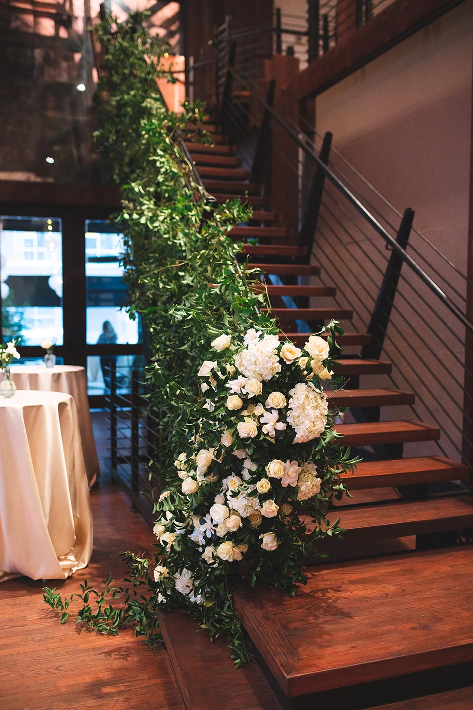 Staircase floral display with greenery and white roses