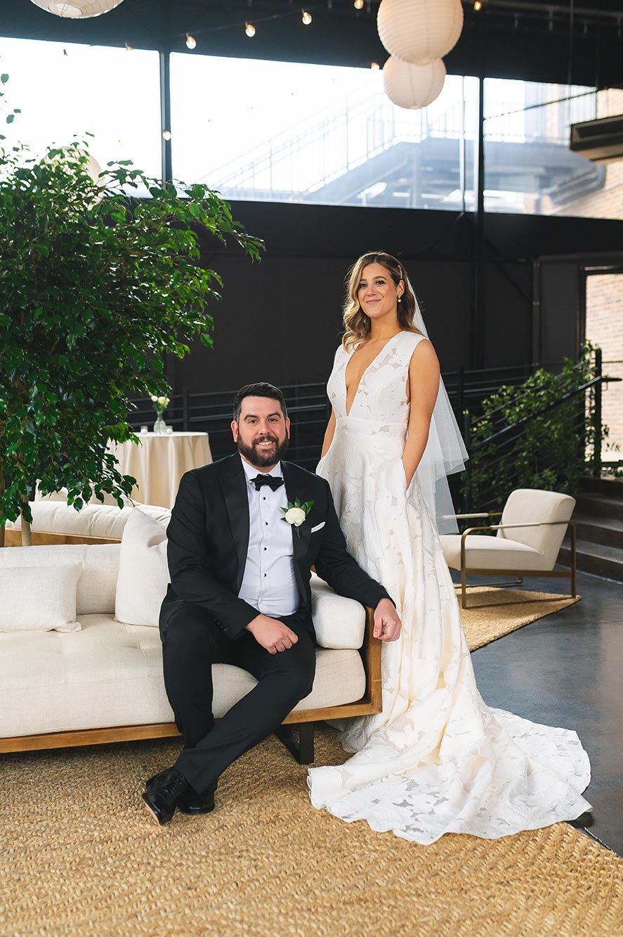 Bride and groom pose for photos in the cocktail patio hour space