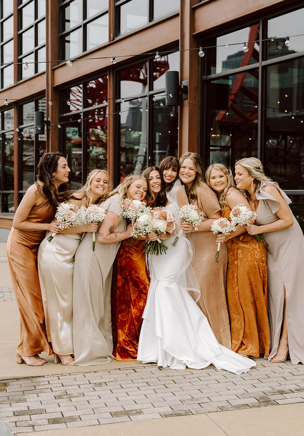 Bride Posing with Bridesmaids Wearing Mix-and-Match Rust Dresses