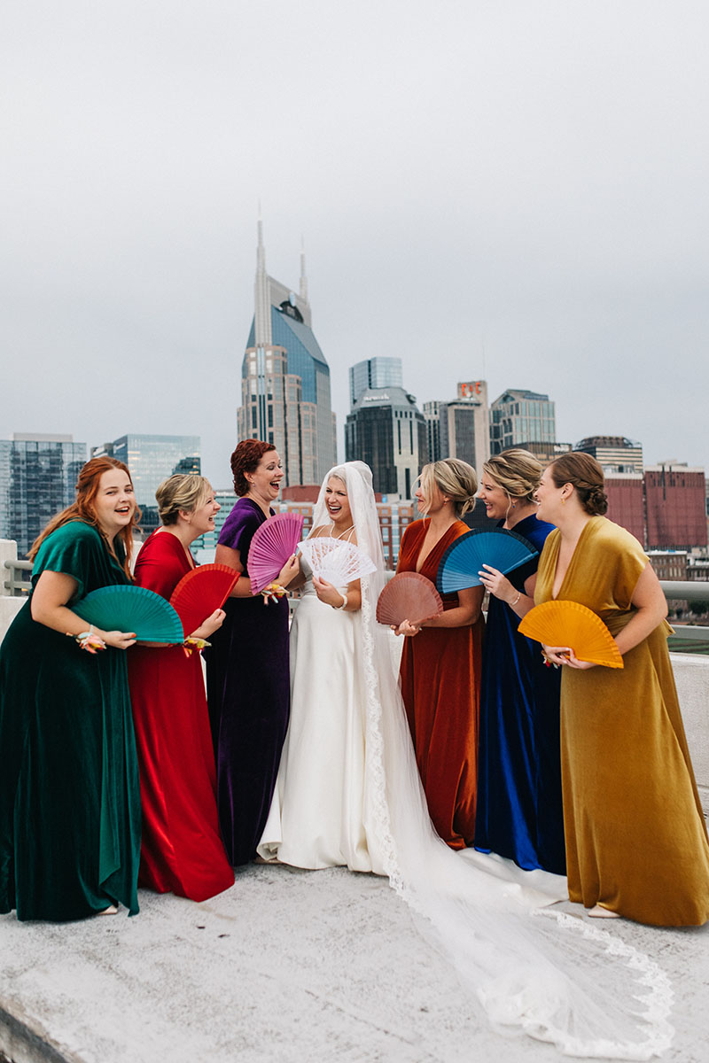 Bridesmaids Wearing Rainbow Velvet Dresses Holding Matching Fans