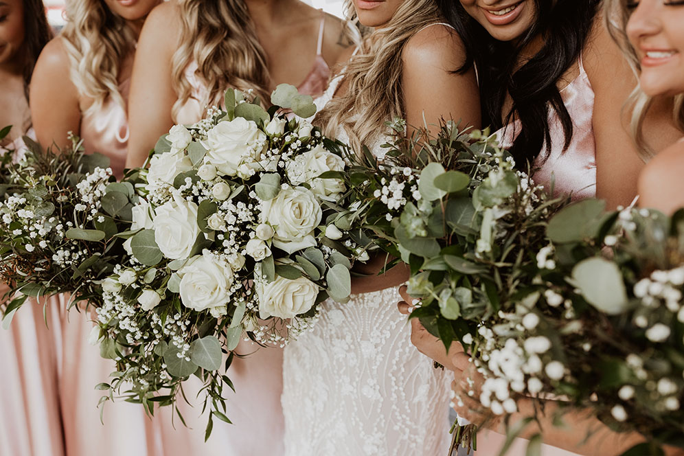 bridesmaids and bridal bouquet of white florals with greenery