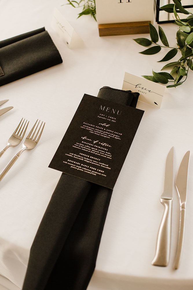 Minimal modern black and white wedding reception menu at place setting