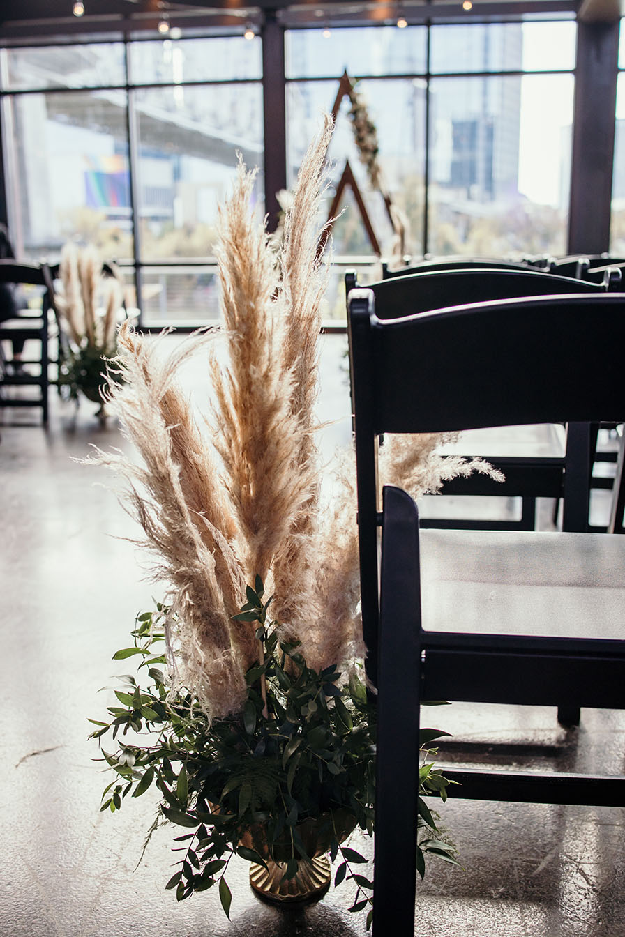 Modern boho wedding ceremony aisle marker with pampas grass and greenery