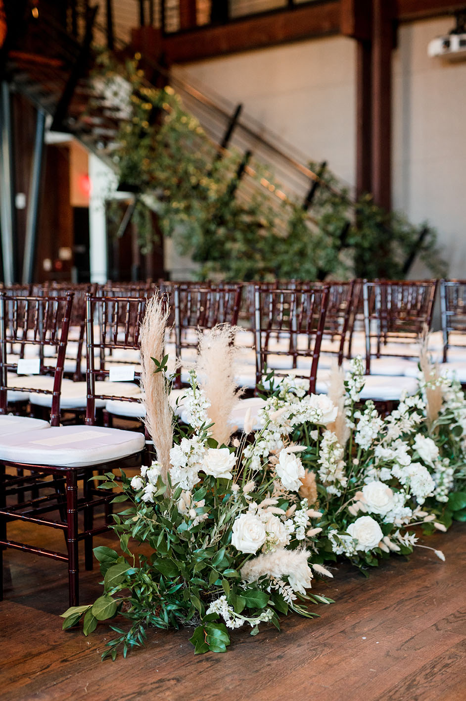 ceremony set up with greenery and boho florals lining the aisle