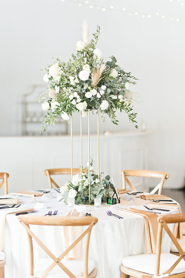 Table Setting with Greenery Arrangement and White Linens
