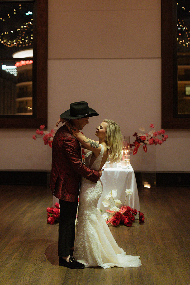 bride and groom embrace during their reception in front of their sweetheart table