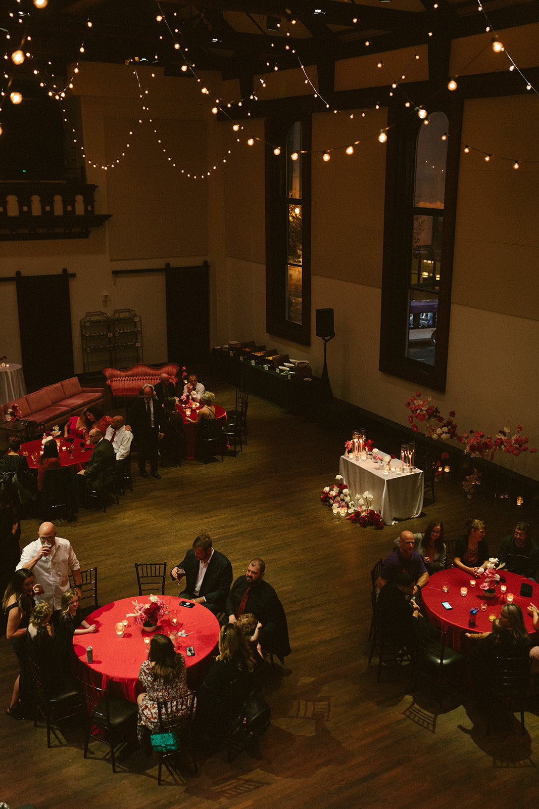 Indoor Wedding Reception at Historic Venue in Downtown Nashville Cascading String Lights Red Table Linens and Sweetheart Table