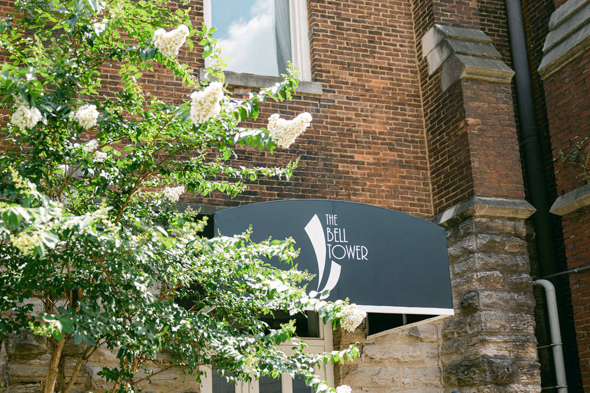 Close-up of the Bell Tower's awning sign with blooming spring tree