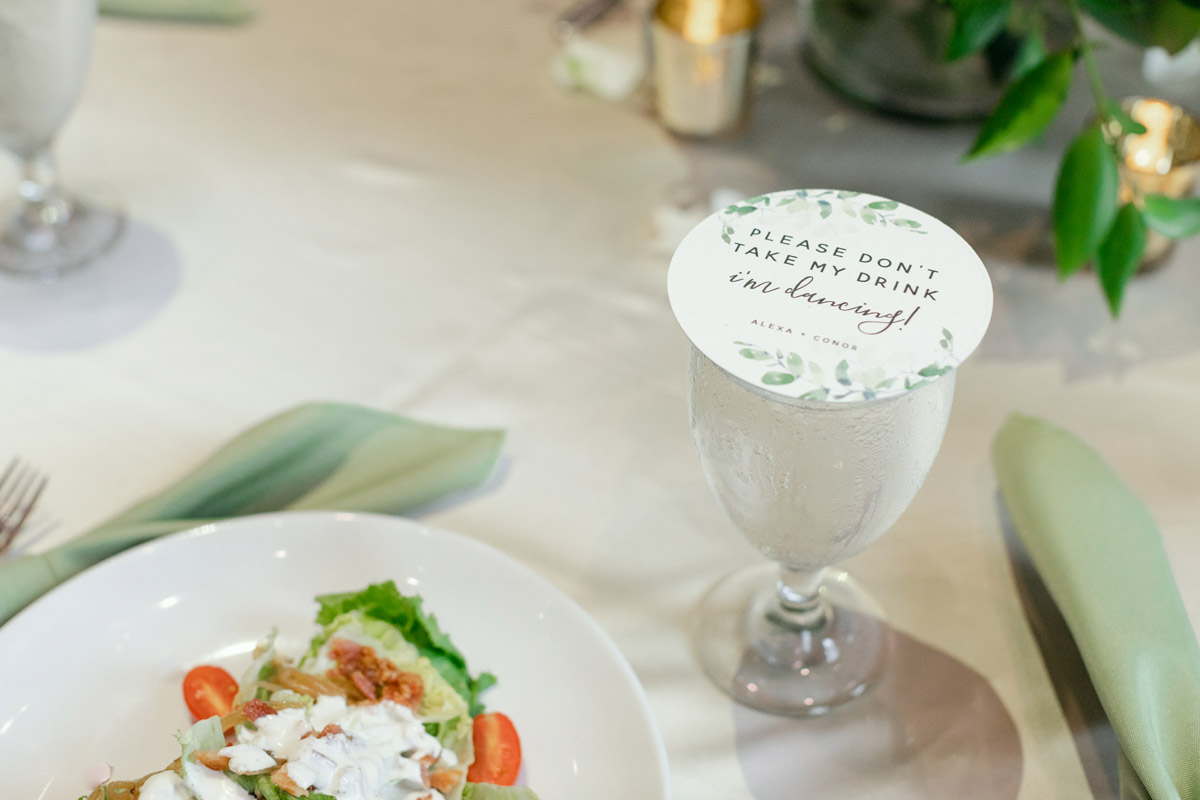 Close up image of a drink cover that reads "please don't take my drink. I'm dancing" for wedding reception