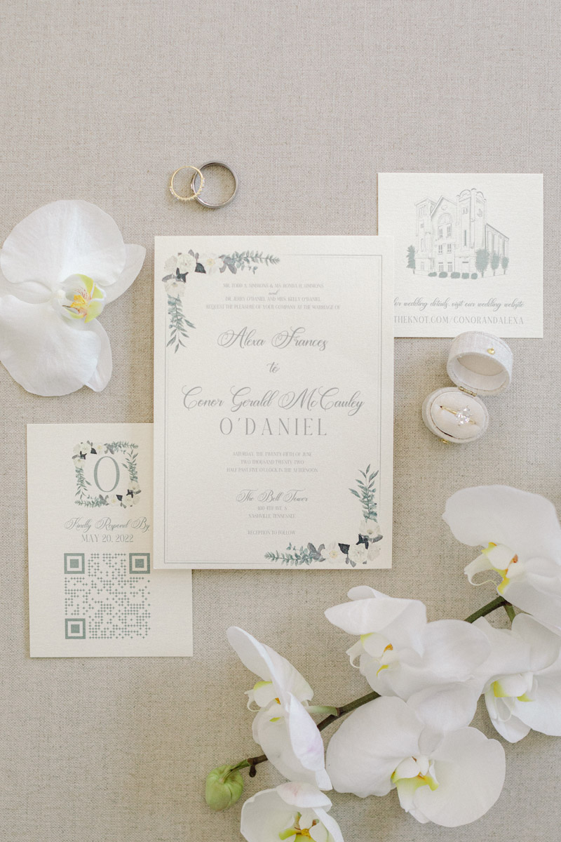 Classic white wedding invitation suite with bridal accessories and white orchids