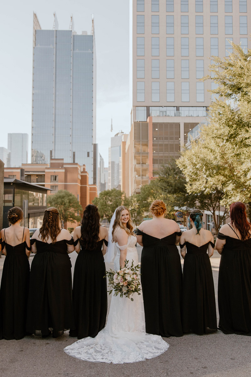 bride and bridesmaids pose on the street in downtown nashville
