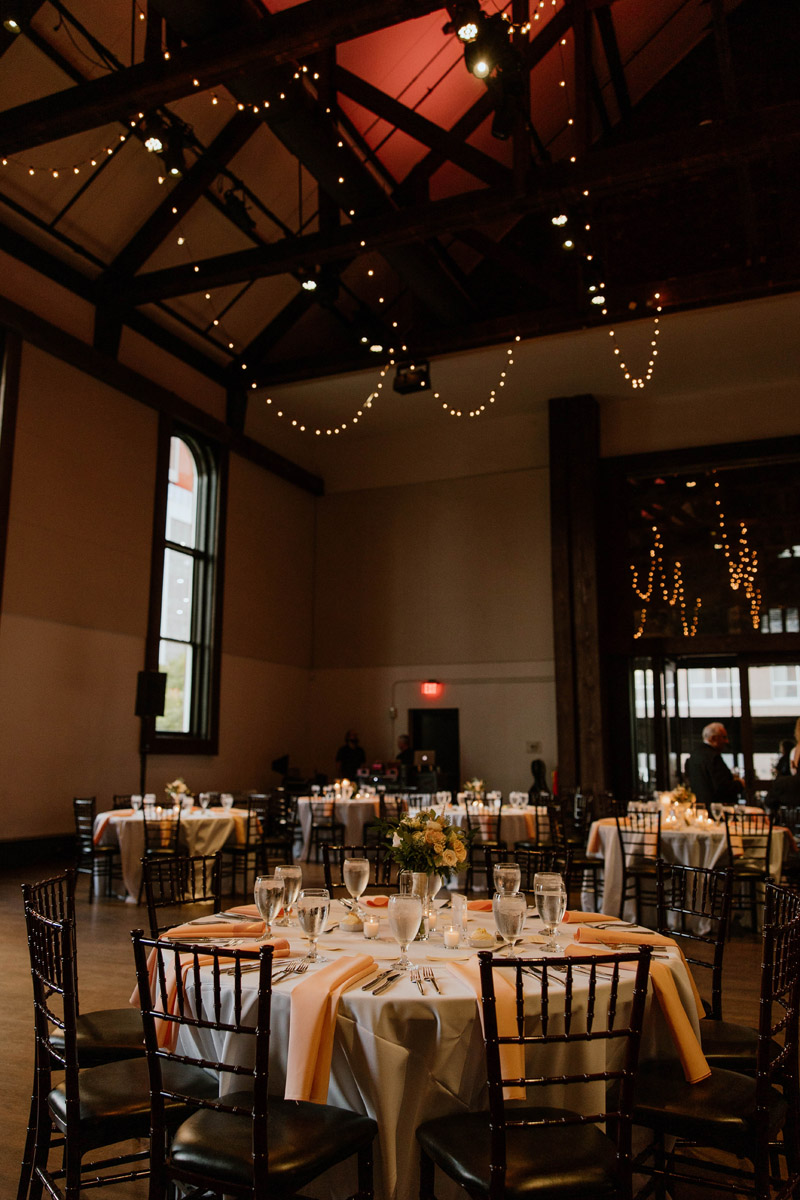 Wedding reception in old church with hanging string lights hanging from wooden beams