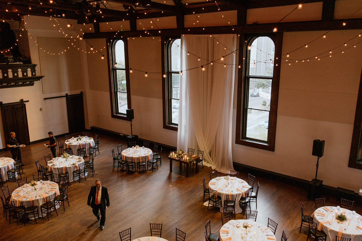 Wedding reception in historical downtown nashville venue decorated with white draping and string lights