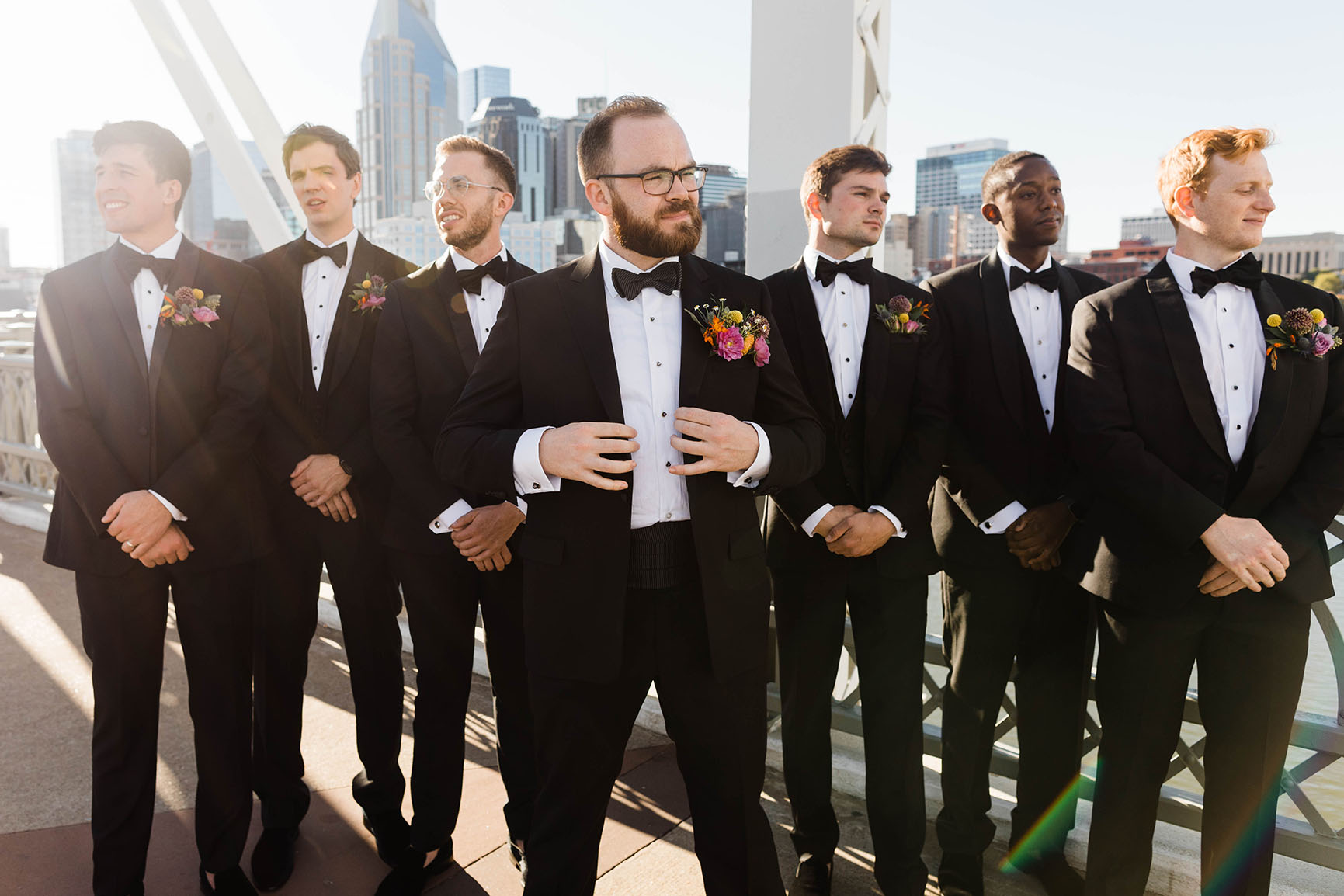 Groom and His Groomsmen on the Pedestrian Bridge in downtown Nashville, all wearing classic black tuxedos