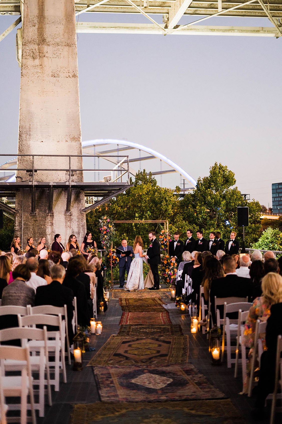 Boho festival-inspired Jewish wedding ceremony at sunset on the riverfront at the Bridge Building