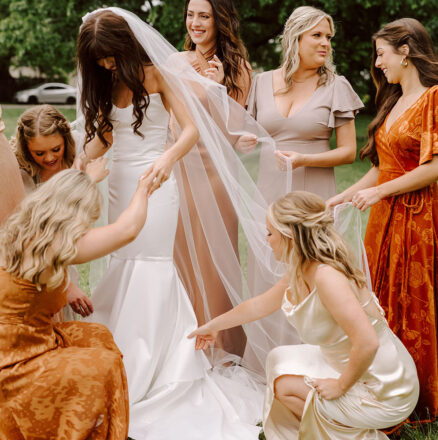 Bridesmaids wearing mix-and-match rust and neutral dresses