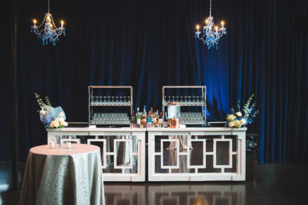 Event bar setup with blue velvet draping and blue chandeliers