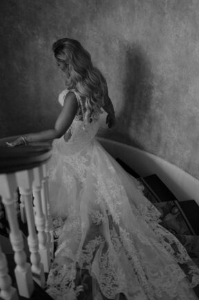 Black and White Photo of Bride on Steps of the Estate