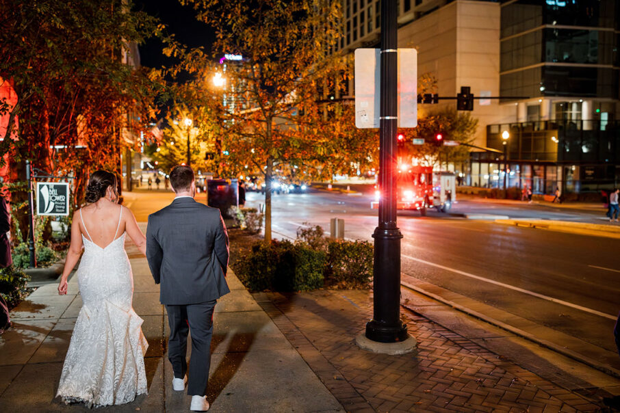 bride and groom walking hand in hand down town nashville after wedding