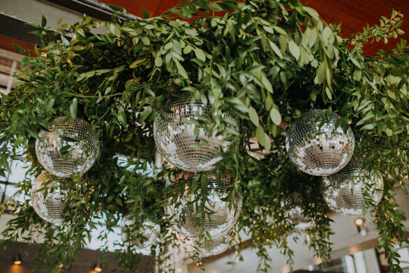Hanging mirror ball and greenery installation for Folklore era-inspired wedding