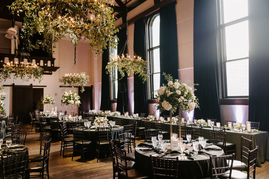 Black and white wedding reception setup with black velvet window draping